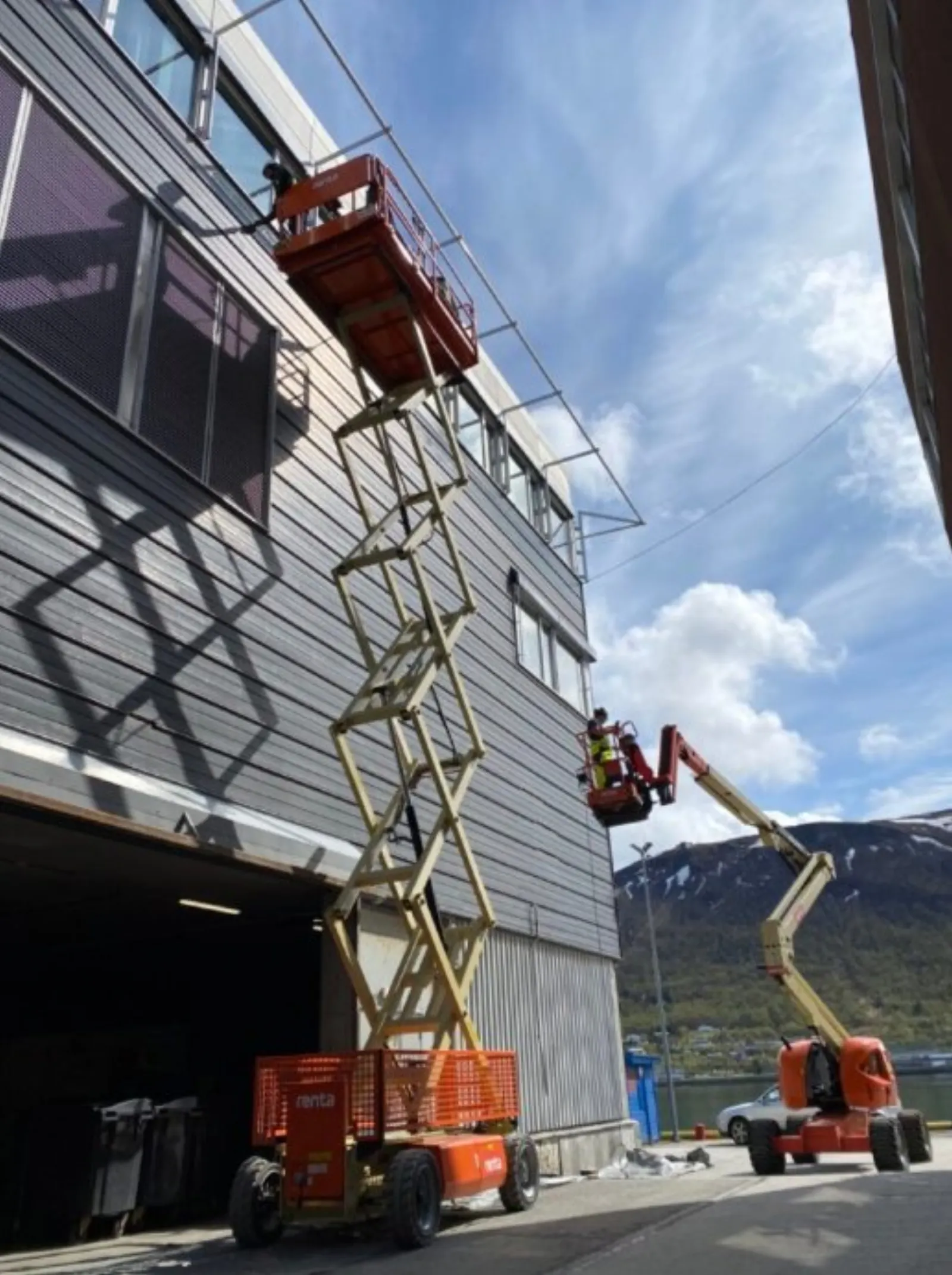 Malerarbeid fra lift på fasade i høyden