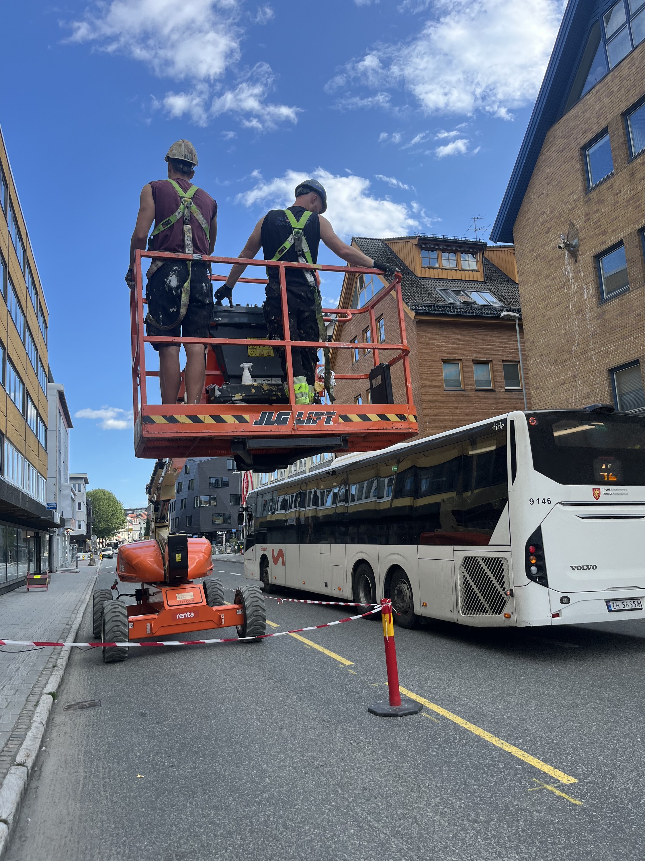 To malere i personløfter i Storgata, med bussen forbi