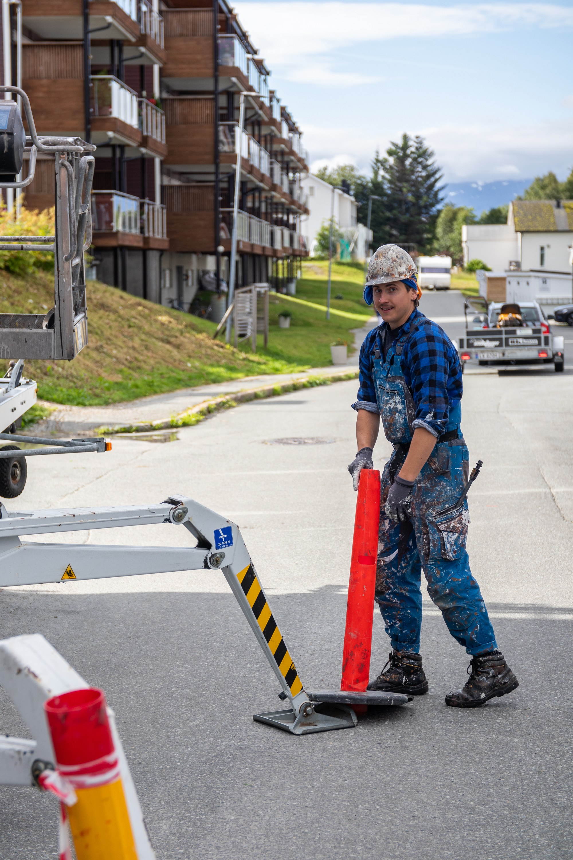 Maler setter ut trafikkjegle ved liften før jobben starter